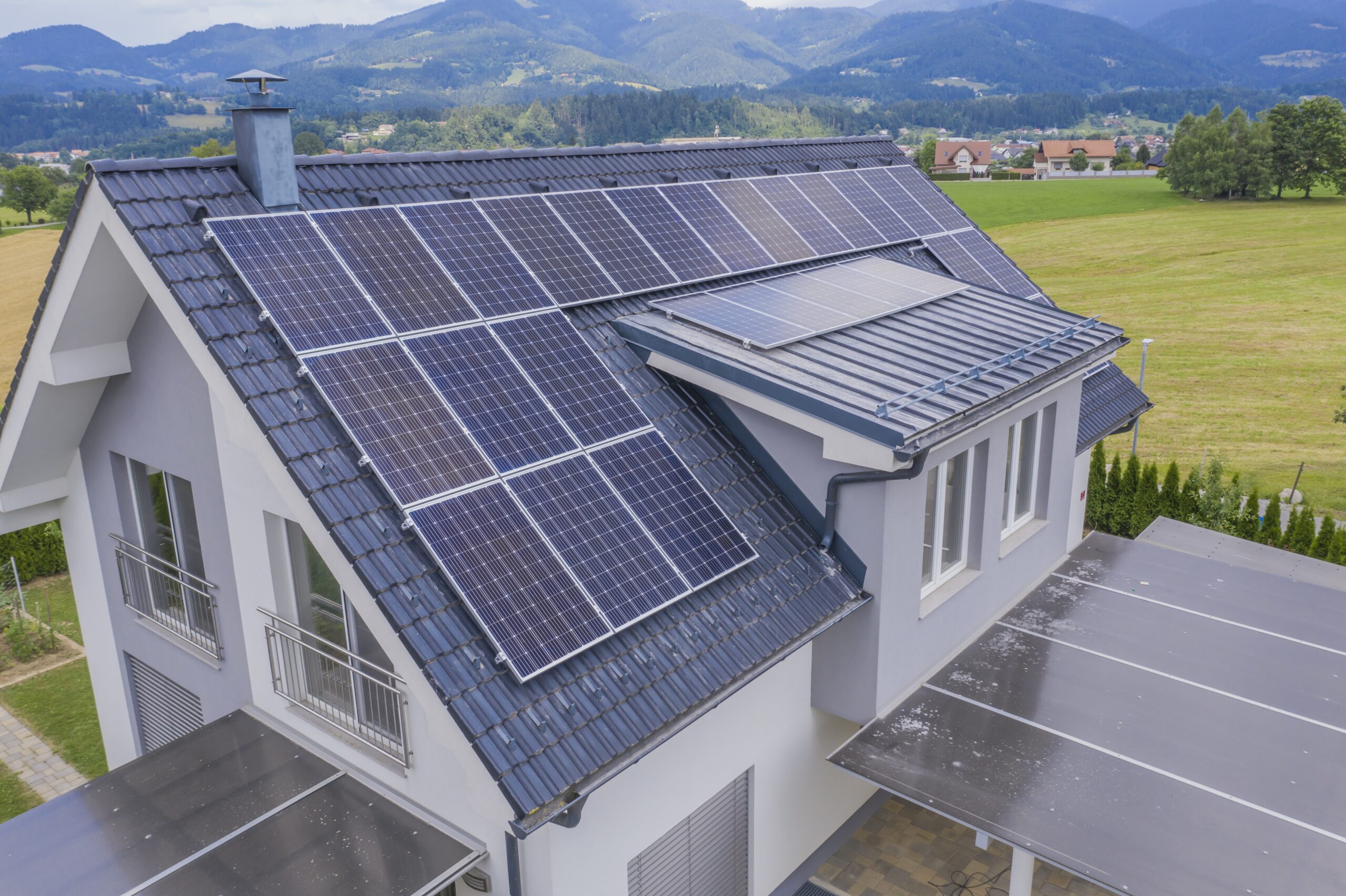 high angle shot of a private house situated in a valley with solar panels on the roof